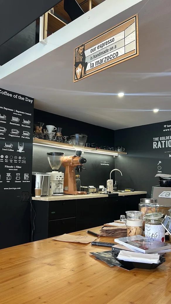 Balcão de madeira, moedor e parede preta da Booínga, em Matosinhos