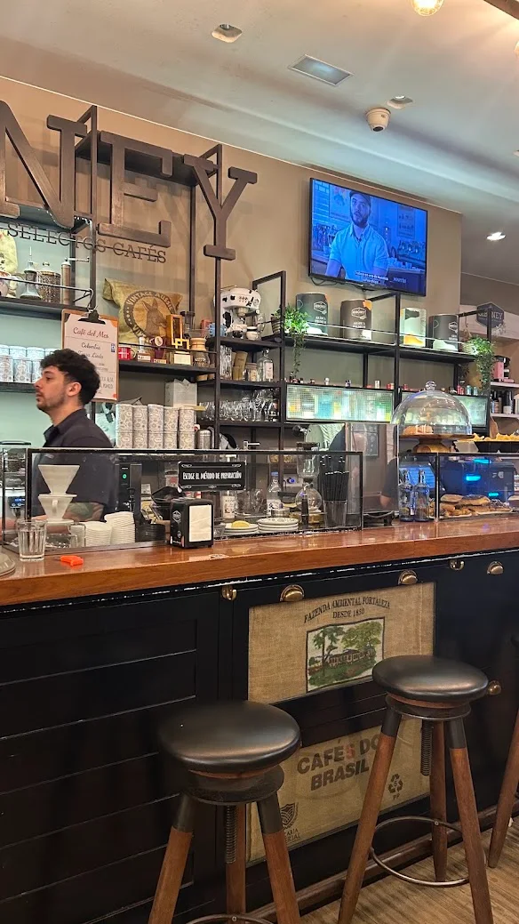 Balcão do Siboney Café, em A Coruña, com banquetas e prateleiras cheias de café